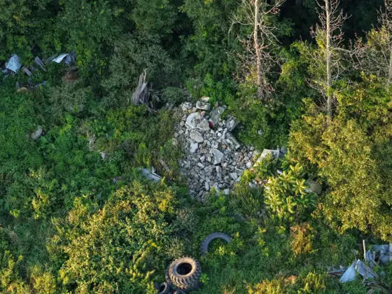 Aerial photo of a rubble pile, tractor tires and scrap metal in brush